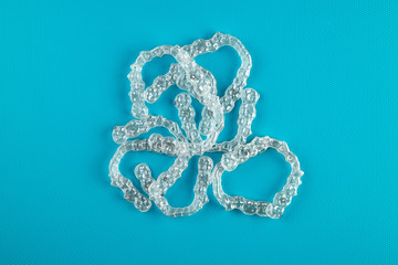 Top view of invisalign braces or invisible retainers on blue background, new orthodontic equipment