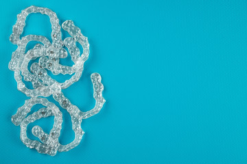 Top view of invisalign braces or invisible retainers on blue background, new orthodontic equipment