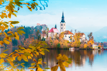 Magical autumn landscape with church on island on Lake Bled (Blejsko jezero), Julian Alps, Slovenia. Amazing places. Popular tourist atraction. Places of pilgrimage. (Meditation, harmony - concept)