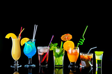 Different tasty cocktails on dark background