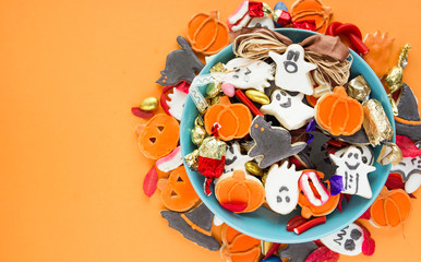 Halloween Jack o Lantern candy bowl with candy and halloween cookies Trick or Treat on orange background