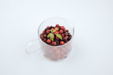 Pitcher of glass with red mulberry and blackberry