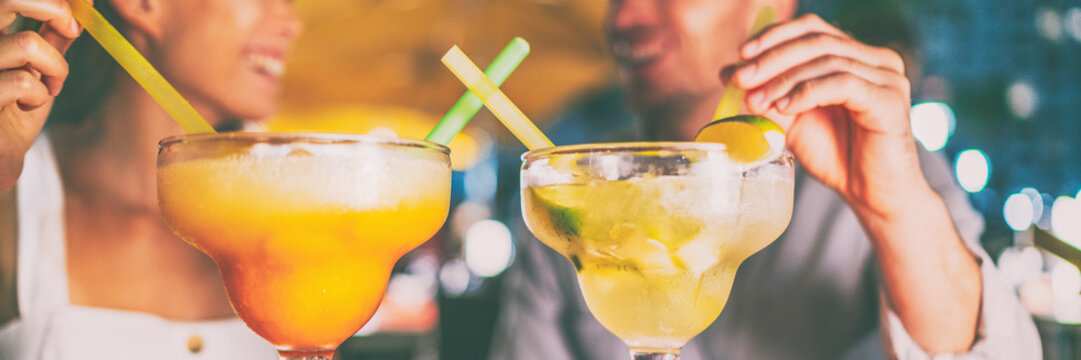 Nightlife party drinks people dating on night out drinking giant margarita and mojito cocktails party couple going out at Miami Ocean drive bar banner panoramic header background.