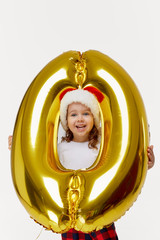 Portrait of little child girl in Santa hat posing with golden 0 zero number balloon isolated on white background. Christmas and new year Credit installments at zero percent concept.