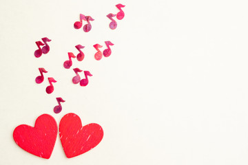 from two wooden hearts fly red notes. The concept of love romantic music