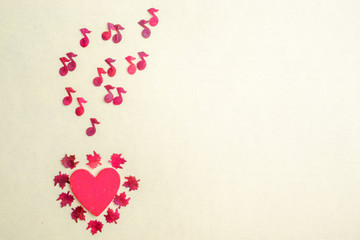 Around the heart there are small maple leaves from which red notes fly out. The concept of romantic love autumn music