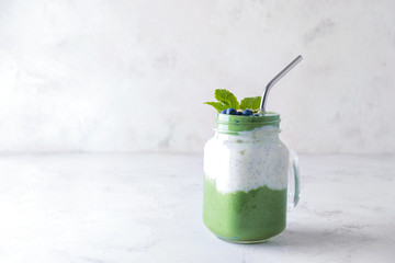 Mason jar of healthy spirulina smoothie on table