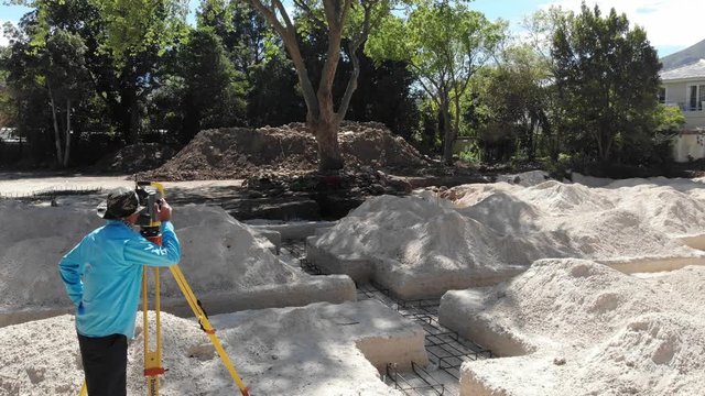 surveyor using a robotic total station theodolite on a construction site