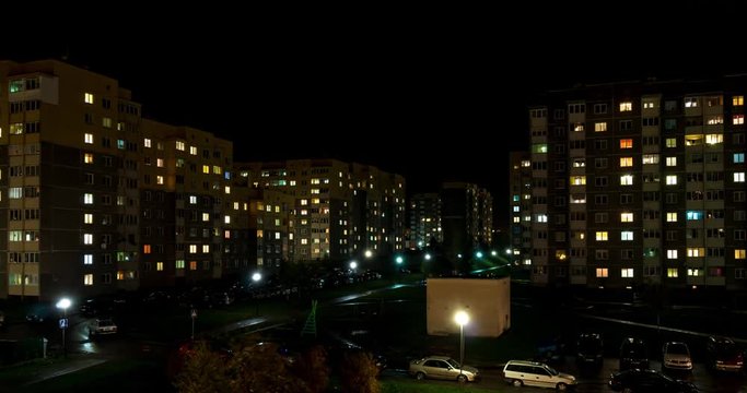 Night panorama time lapse of light in windows of multistory buildings. life in big city
