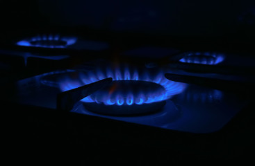 natural butane blue gas burning on kitchen gas stove in dark room