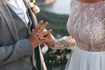 The bride puts the ring on the finger groom. Wedding event.