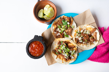 Mexican birria tacos with onion and cilantro on white background