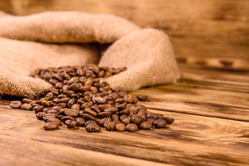 Sackcloth and scattered coffee beans on wooden table