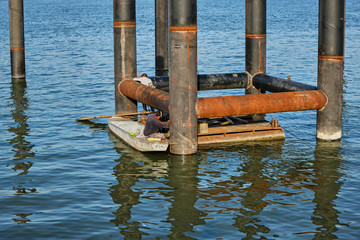 Welders are working on a pipes construction in the water