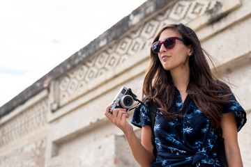 Tourist woman with retro style camera at Mitla, Mexico