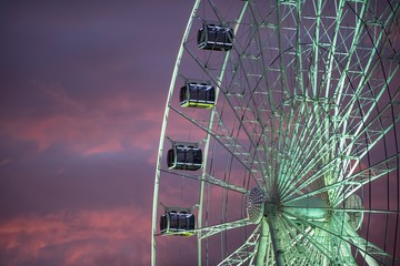 Ferris wheel illuminated with colorful sky 