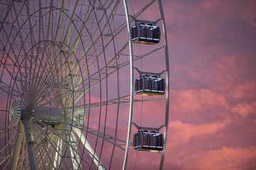 Illuminated ferris wheel with colorful sky in the evening
