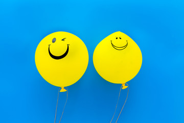 Happiness emotion. Yellow balloon with smile on blue background top view