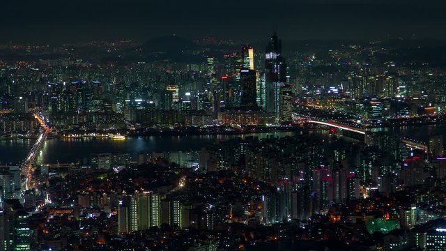 Timelapse ships and boats in large Seoul ocean bay and illuminated overpass highway bridges connecting city parts with buildings and skyscrapers at night zoom in