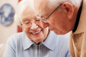 Senior couple watching old photographs at home