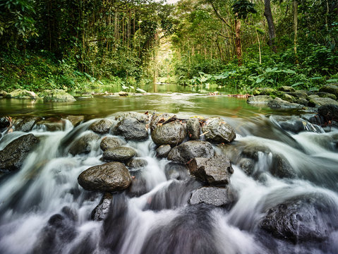 River flowing through rocks in rainforest at Waipio Valley