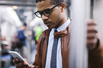 Businessman with smartphone on the subway train