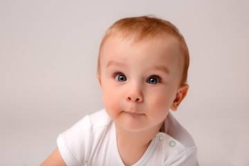 Naklejka premium cute toddler boy on white background looking in frame, space for text, baby 8 months on white background