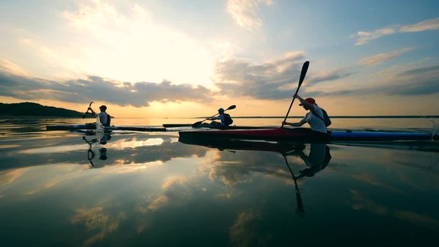 Sunset waters with rowers floating along them