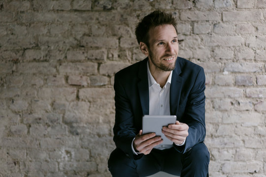 Portrait of smiling businessman holding tablet