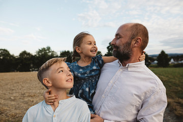 Affectionate father with two children outdoors