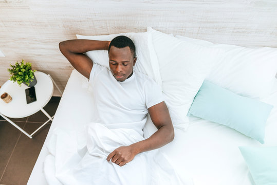 Young Man Lying In Bed At Home