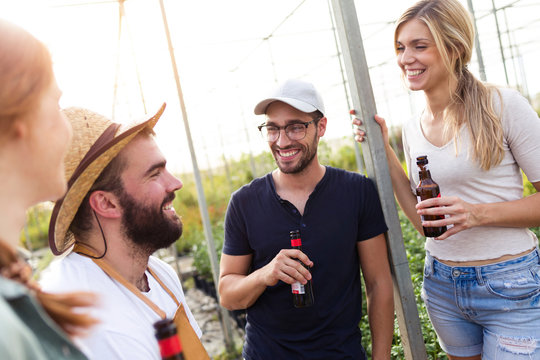 Group of friends drinking beer and enjoying time in the greenhouse