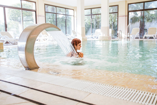 Young woman relaxing in swimming pool of a spa