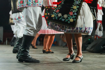 Close up of legs of young Romanian female and male dancers in traditional folkloric costume. Folklore of Romania