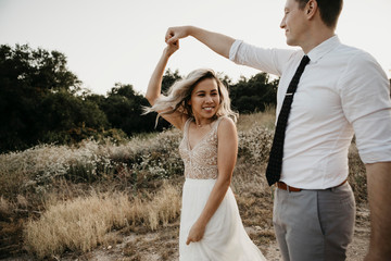 Affectionate bride and groom dancing in the countryside