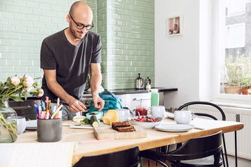 Man in a kitchen, packing snacks for lunch break
