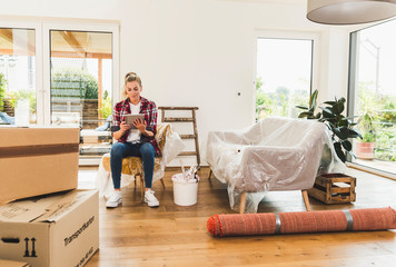 Woman moving into new home using tablet