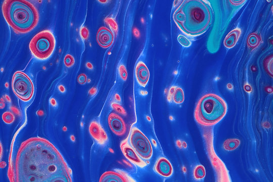 Neon pink ameobas flow horizontally through bright blue tubes in this abstract acrylic painting for backgrounds.