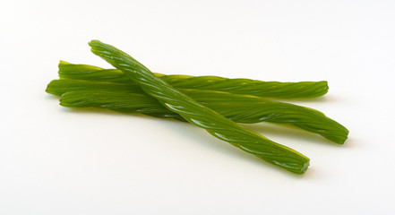 Several pieces of apple flavor licorice on a white background.