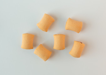 Several bite size dog snacks on a white background.