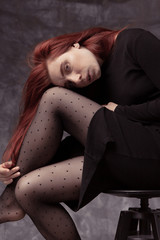 Beautiful feminine girl in a dress on a canvas background. Art portrait