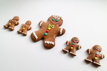 Obraz premium Different sizes of Gingerbread men cookies isolated on white background. Christmas tradition. Top view.