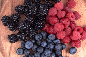 Natural colorful set of blackberries, blueberries and raspberries collected in last summer days