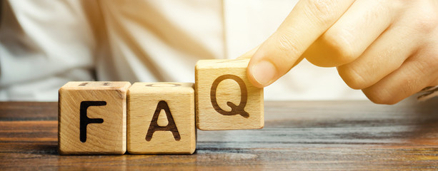 Businessman puts wooden blocks with the word FAQ (frequently asked questions). Collection of frequently asked questions on any topic and answers to them. Instructions and rules on Internet sites - obrazy, fototapety, plakaty