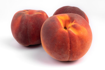 Fototapeta na wymiar Front view of three red and yellow organic vivid peaches