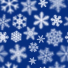 Christmas seamless pattern of white defocused snowflakes on blue background