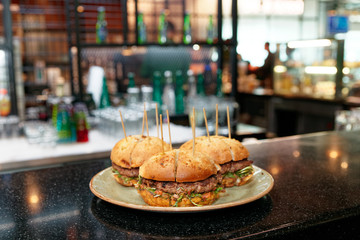 Burgers with toothpicks on bar counter