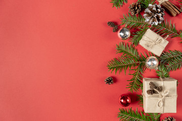 Christmas handmade gift boxes decorated with craft paper and branch, pine cone, cinnamon on red background. Christmas, winter, new year concept. Flat lay, top view, copy space