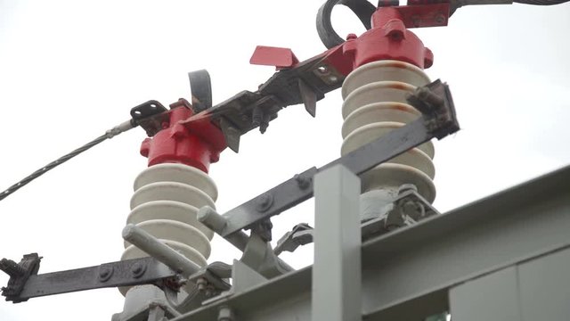 Close up of Electrical poles with wires and insulators at the electrical substation. Circuit breaker high voltage. Part of high-voltage substation with switches and disconnectors.
