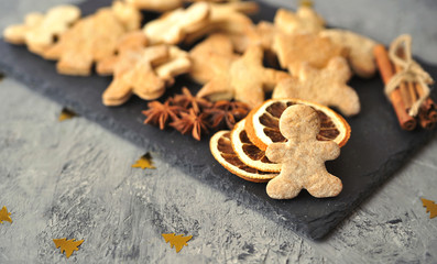 Christmas cookies, cinnamon, dried oranges on wooden background.